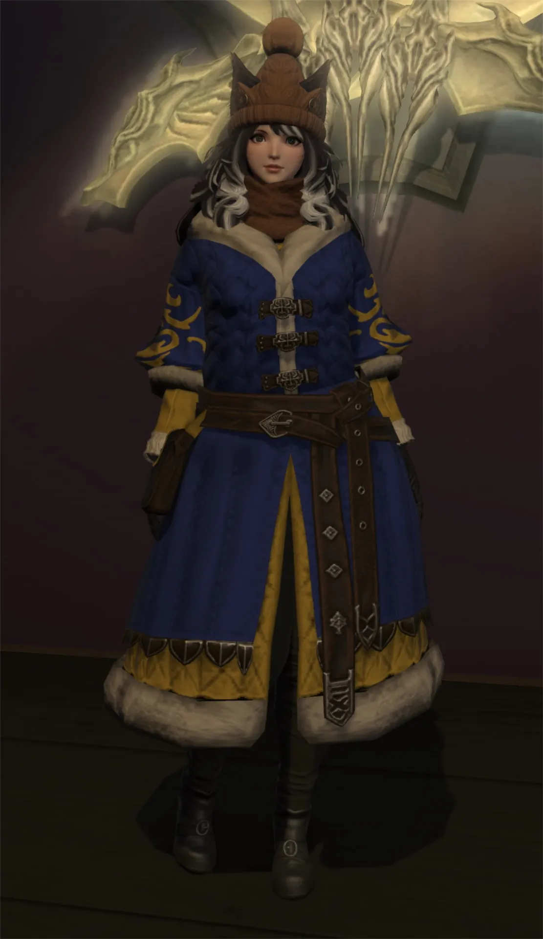 Lazne in a warm blue winter coat and brown kupo hat, with a scarf around her neck.